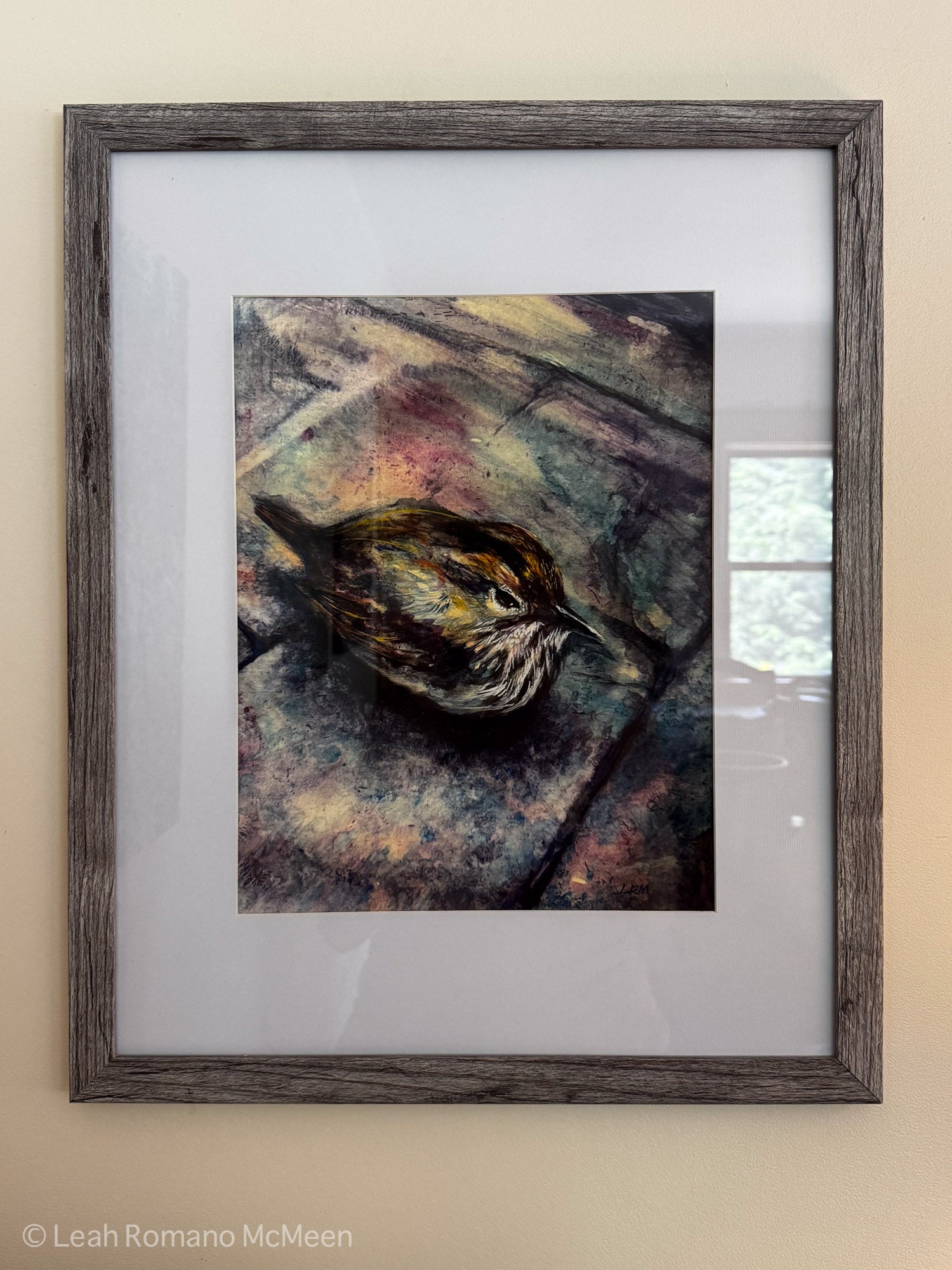 Framed artwork of a bird on a textured surface with a wooden frame.