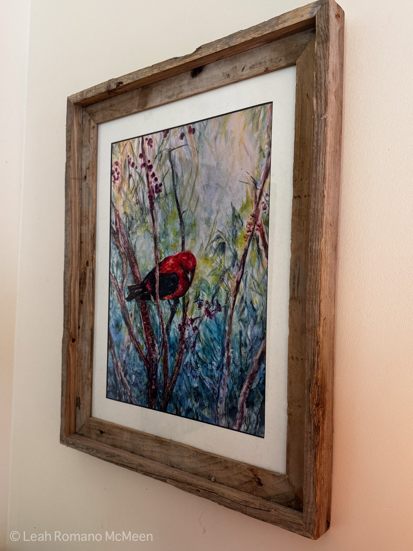 Framed artwork of a red bird on a branch with a natural wood frame.